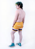 back view of Xander modeling the nonbinary pride boardshort when they were a size 32