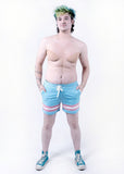 front view of Xander modeling the trans pride boardshort when they were a size 32