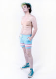 side view of Xander modeling the trans pride boardshort when they were a size 32