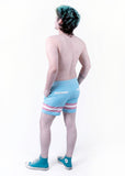 back view of Xander modeling the trans pride boardshort when they were a size 32
