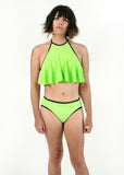 front side view of Angel modeling the tucking bikini and ruffle top in green as a set