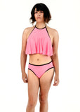 front side view of Angel modeling the tucking bikini and ruffle top in pink as a set