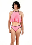 front view of Angel modeling the tucking bikini and ruffle top in pink as a set